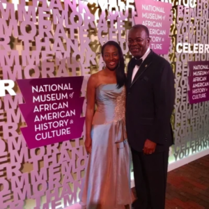A man and woman posing for a picture in front of a wall.