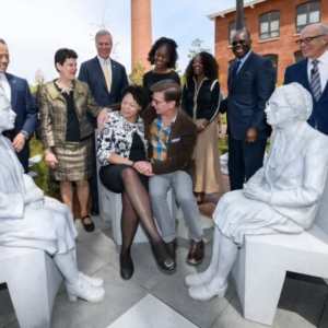 A group of people sitting on top of white statues.