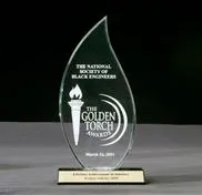 A glass award with the golden torch logo on it.