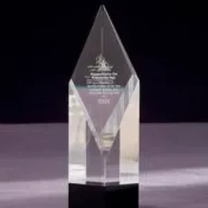 A clear glass trophy on top of a table.