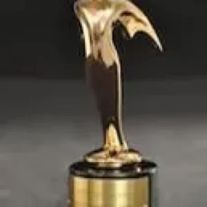 A gold statue of a dolphin on top of a black pedestal.