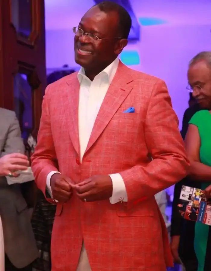A man in a red suit standing next to other people.
